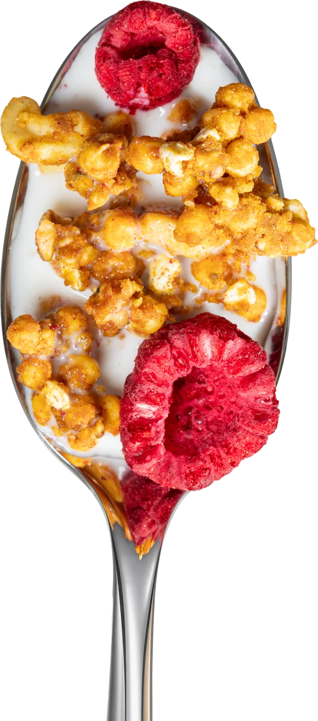 Raspberry Coconut Cashew granola with milk on a spoon