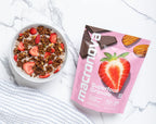 A bowl of Strawberry Chocolate granola with milk beside its Macronova pouch.